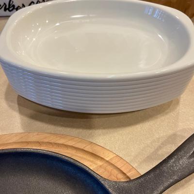 K73- cast iron pan w/serving board, 10 plastic trays, small casserole