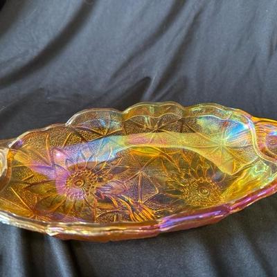 Sale Photo Thumbnail #763: Vintage Carnival Glass Oval Shaped Amber Serving Dish with Sunflowers on UnderSide

Handles on each end, Dish reflects an array of colors dependent on the light, you may see greens, mauves, blues, amazing! 

This dish is in excellent condition with no cra