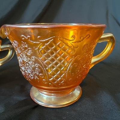 Sale Photo Thumbnail #792: This marigold carnival glass cup and creamer set have beautiful floral and lattice patterns which is also known as Normandie. It was produced by Federal glass from 1933 to 1940. Both are in very good condition, No chips or cracks. 

Beautiful set for use 