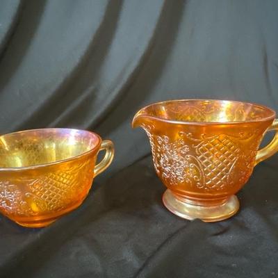 Sale Photo Thumbnail #791: This marigold carnival glass cup and creamer set have beautiful floral and lattice patterns which is also known as Normandie. It was produced by Federal glass from 1933 to 1940. Both are in very good condition, No chips or cracks. 

Beautiful set for use 
