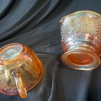 Sale Photo Thumbnail #794: This marigold carnival glass cup and creamer set have beautiful floral and lattice patterns which is also known as Normandie. It was produced by Federal glass from 1933 to 1940. Both are in very good condition, No chips or cracks. 

Beautiful set for use 