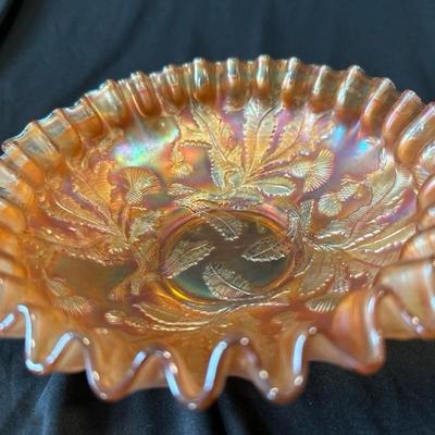 Sale Photo Thumbnail #806: This listing is for a vintage Fenton marigold carnival glass bowl that has the Thistle pattern on it. The bowl measures around 8 and 1/4 inches wide and stands around 2 and 1/2 inches tall. The bowl is in excellent condition with no cracks or chips. 

We 