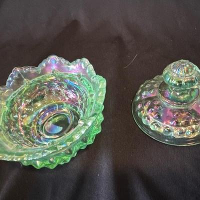 Sale Photo Thumbnail #816: Green iridescent hobnail Fenton bowl with lid, very good condition. Fenton can be seen stamped into the glass on lid and bowl. Sticker on inside.

Approximately 3.5in tall and 3.5in wide