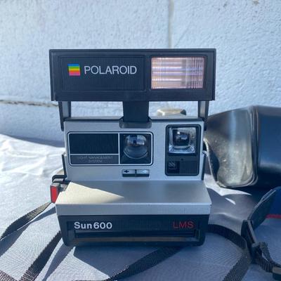 A Fun Polaroid sun600 Camera, with a EOS Canon Rebel E2 Camera