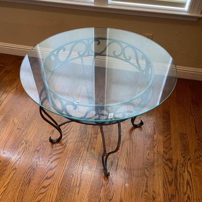 Glass top table with scrollwork iron base