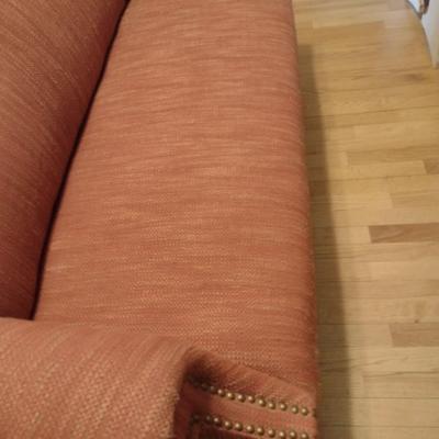 Camel Back Upholstered Loveseat with Brass Tack Accents