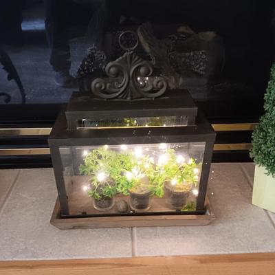 FAUX BUSH AND FOLIAGE IN A LIGHTED GLASS AND METAL TERRARIUM