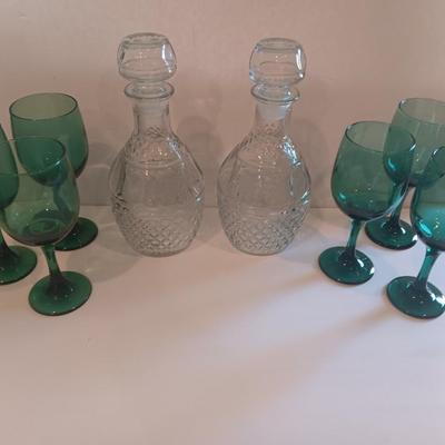Two matching Princess House decanters with six green stemmed glasses