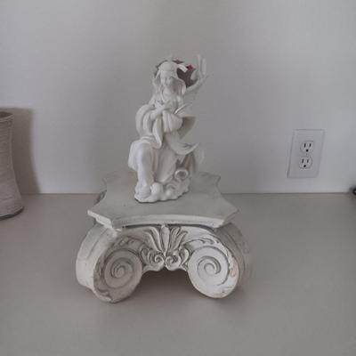 WHIMSICAL ANGEL RESTING ON AN ORNATE STAND