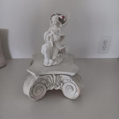 WHIMSICAL ANGEL RESTING ON AN ORNATE STAND