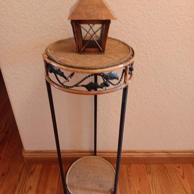 Two-tiered Metal and wicker plant stand with small metal votive lantern