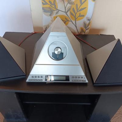 Cool Radio Shack light up am/FM CD / Cassette Clock radio with speakers on a Black media cabinet stand.