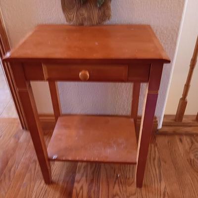 Small wooden accent table with drawer and unique pottery birds in a nest artwork