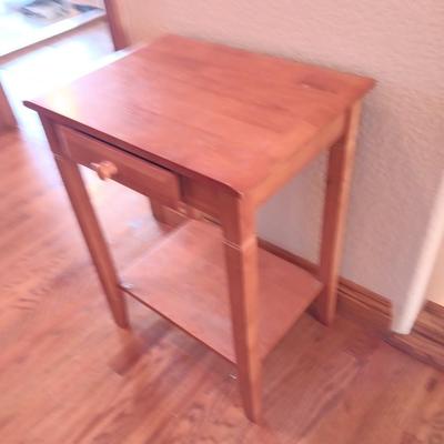 Small wooden accent table with drawer and unique pottery birds in a nest artwork