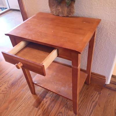 Small wooden accent table with drawer and unique pottery birds in a nest artwork