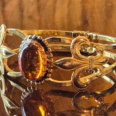 Hinged Gold Tone Bracelet with an Amber Colored Stone