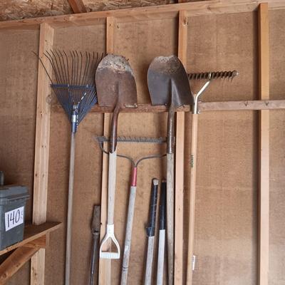 AN ASSORTMENT OF YARD TOOLS AND A SPREADER