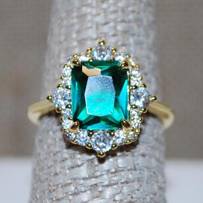Size 8 Green Shimmer Cushion Cut Stone Ring with Clear Stone Surrounds on a Gold Tone Band (4.1g)