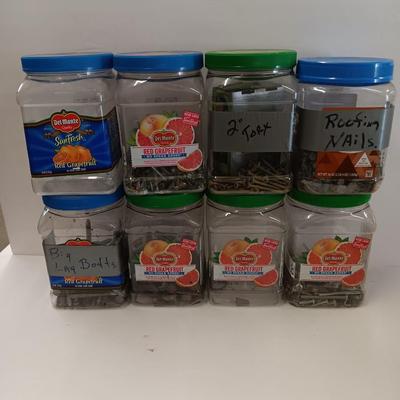 8 plastic lidded containers with home hardware - bolts - screws - nails - and more