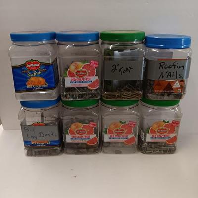 8 plastic lidded containers with home hardware - bolts - screws - nails - and more