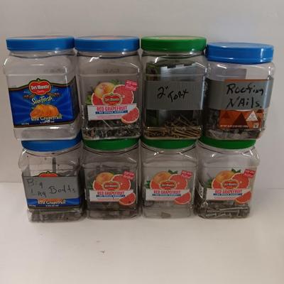 8 plastic lidded containers with home hardware - bolts - screws - nails - and more