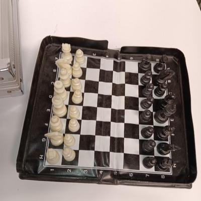 Poker chips in a metal case and a chess set