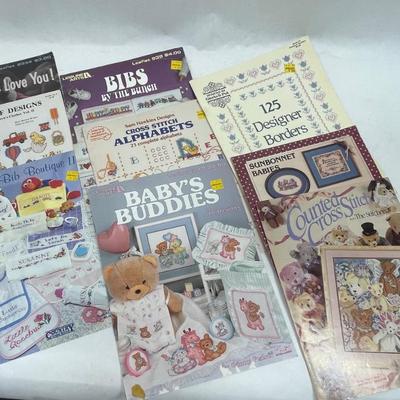 Lot of nine instruction books / patterns for baby cross-stich items