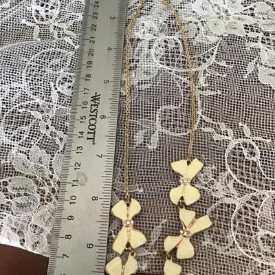 Gold toned necklace creme colored bows necklace