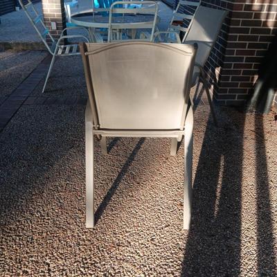 ROUND GLASS TOP PATIO TABLE WITH 4 CHAIRS AND 2 ADDITIONAL STACKING CHAIRS