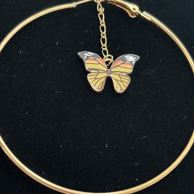 Gold toned hoop earrings with dangling butterfly