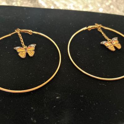 Gold toned hoop earrings with dangling butterfly