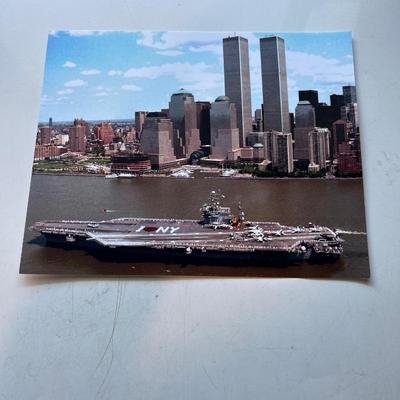 Photo of Aircraft carrier with World Trade Center in background