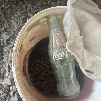 Bucket of Small Stakes and Glass Coke Bottle
