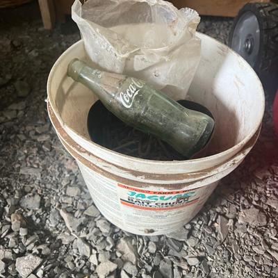 Bucket of Small Stakes and Glass Coke Bottle