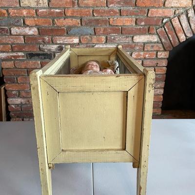 Antique Doll in a Crib