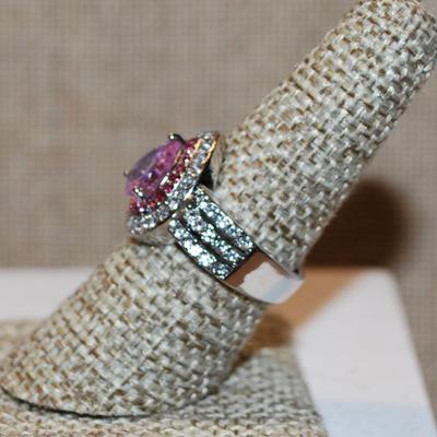 Size 7¾ Pink Pear Cut Center Stone Ring with Clear Stones Sides and Surrounds on a Silver Tone Band (5.7g)
