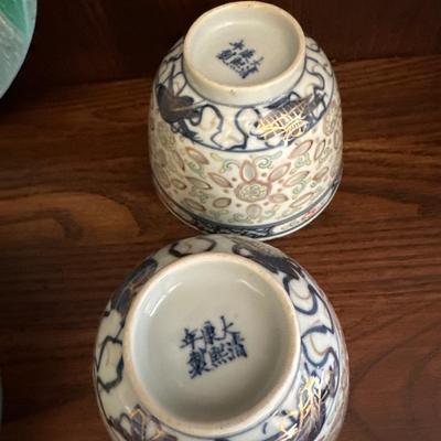 Decorative shelf items, including Asian antique cups