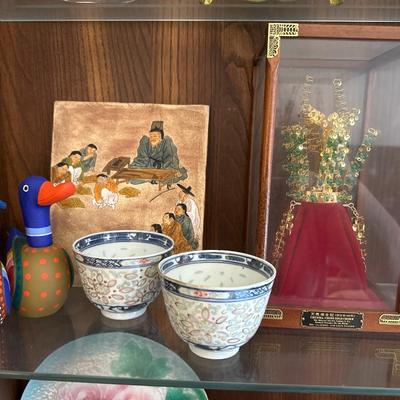 Decorative shelf items, including Asian antique cups