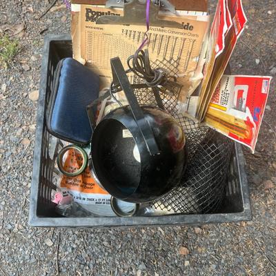 Black plastic milk crate with various items