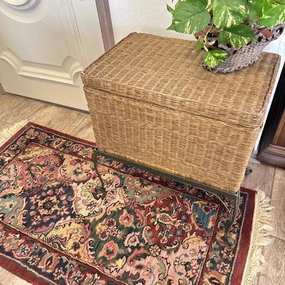 Wicker chest on stand with a rug