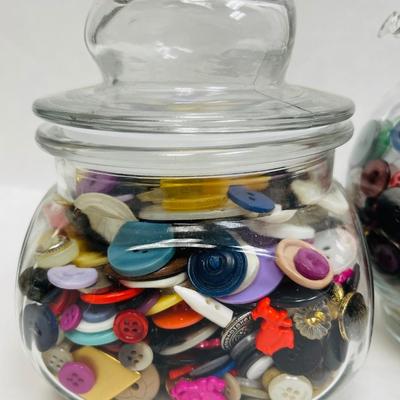 4 glass containers full of vintage buttons