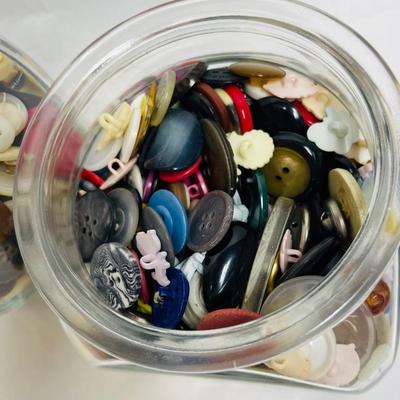 4 glass containers full of vintage buttons
