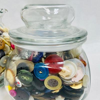 4 glass containers full of vintage buttons