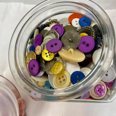 4 glass containers full of vintage buttons