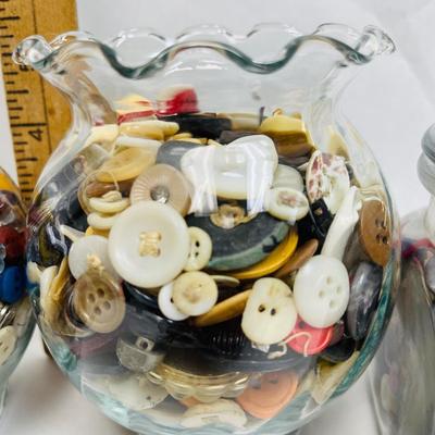 4 glass containers full of vintage buttons