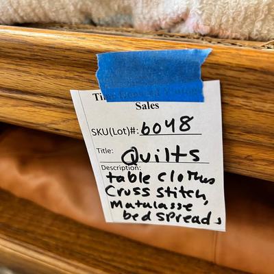 Wooden cabinet baskets full of antique quilts