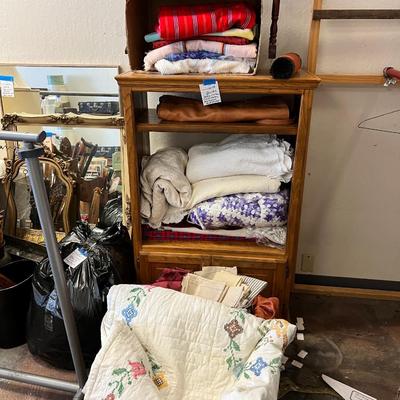 Wooden cabinet baskets full of antique quilts