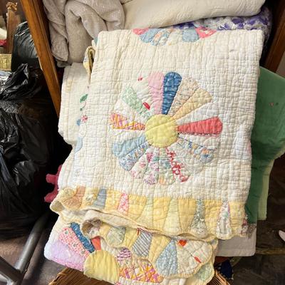 Wooden cabinet baskets full of antique quilts