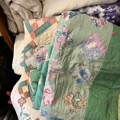Wooden cabinet baskets full of antique quilts