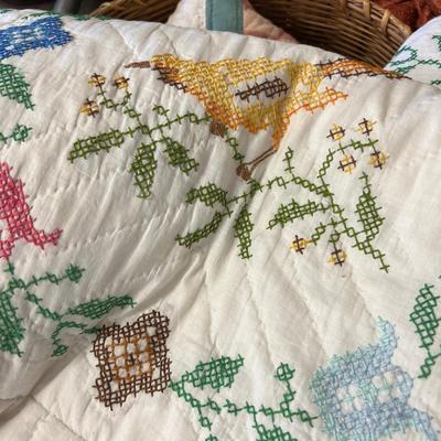 Wooden cabinet baskets full of antique quilts